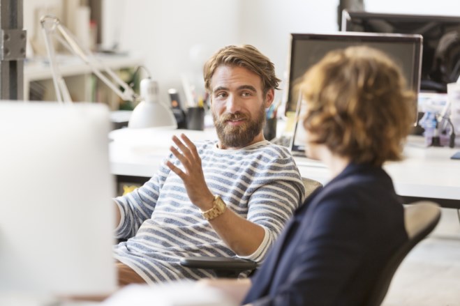 Ansatte sitter ved pc-en og diskuterer