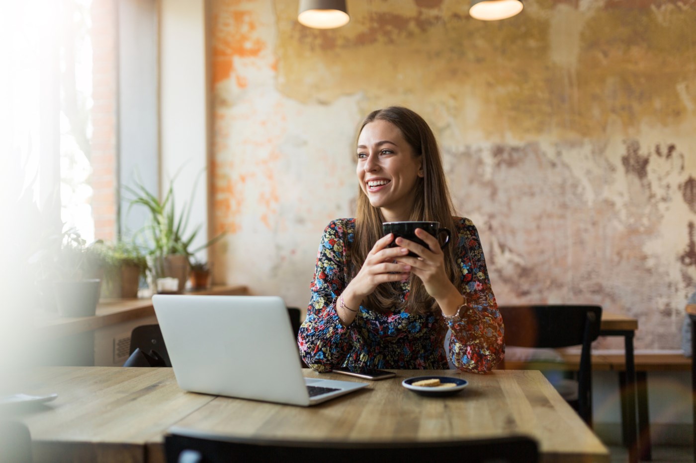 Jente smiler ved pc-en