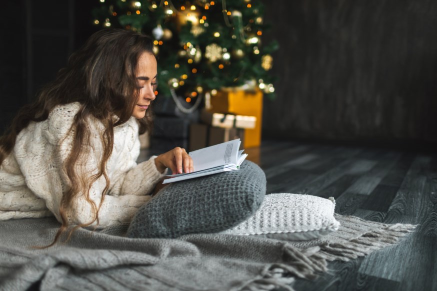 dame leser bok under juletreet